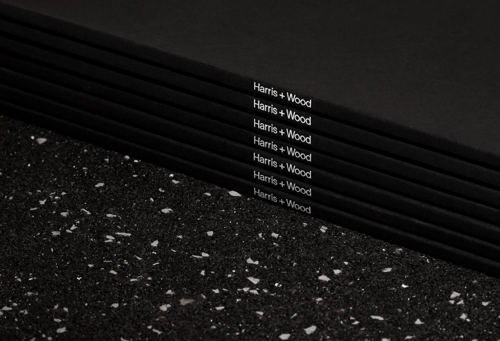 Stacked Harris + Wood folders with logo printed on the spine
