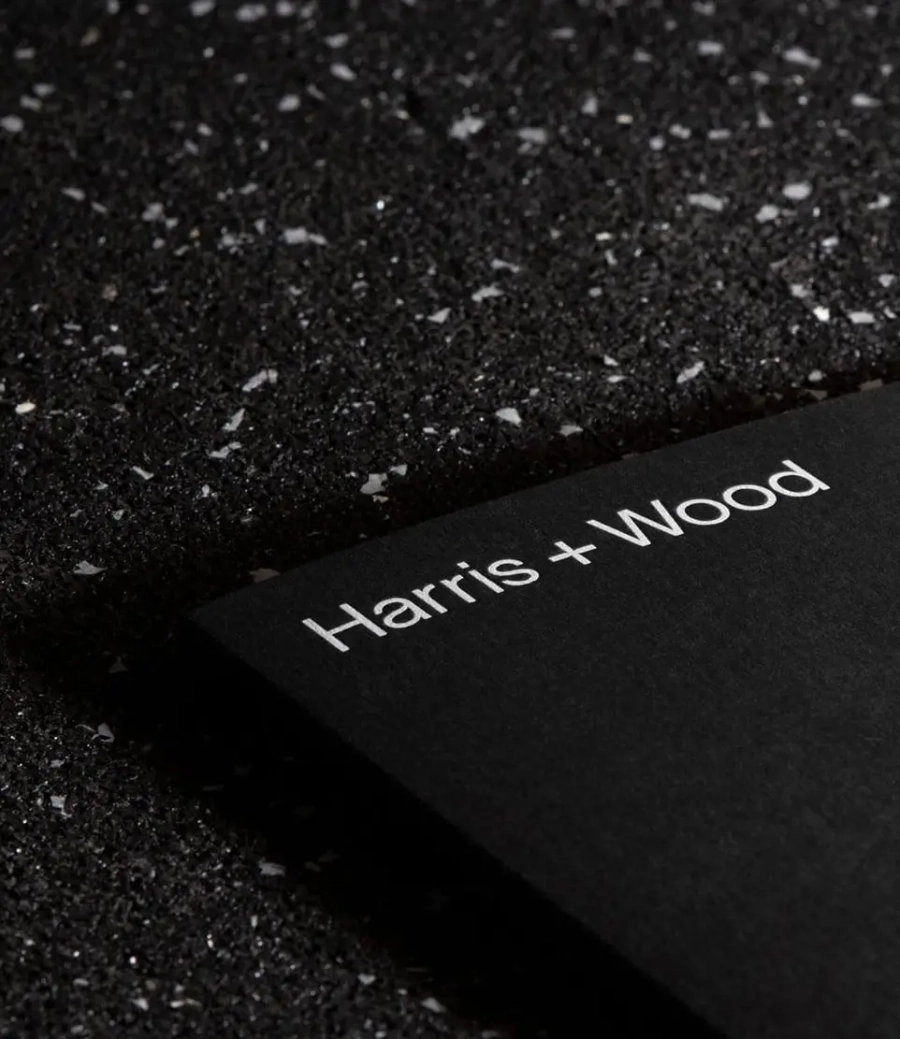 Black Harris + Wood brochure cover on speckled black surface