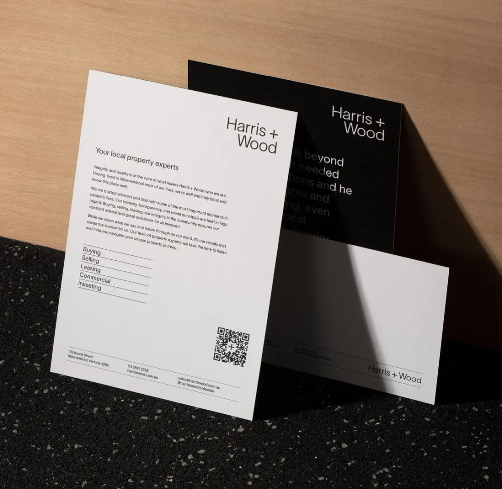 A cluster of printed Harris + Wood brand and property flyer designs